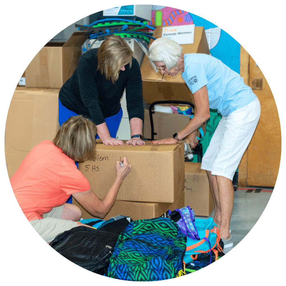 Photo of three women packing a cardboard box