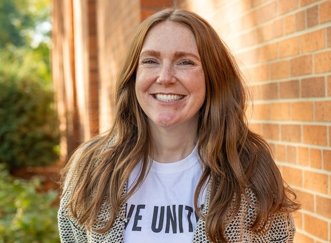 white woman with red hair smiling at the camera